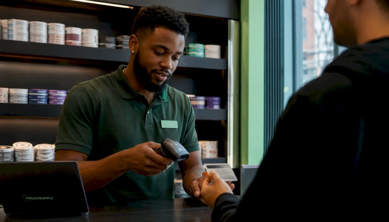 Retail clerk scanning ID at store counter