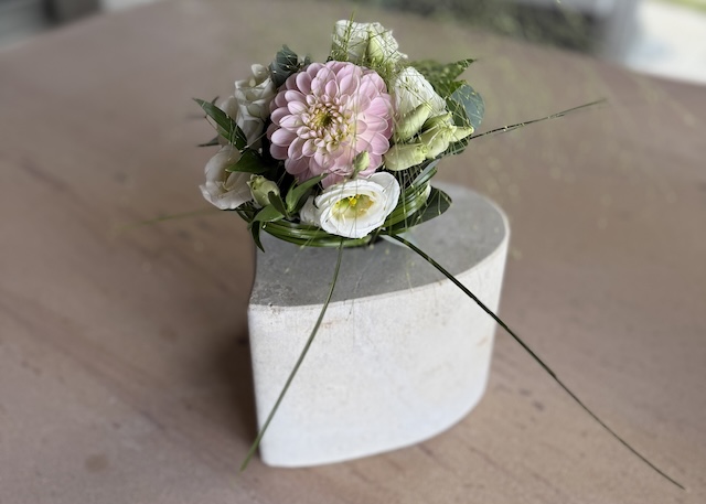Das Liebstück aus Kalkstein mit einem Blumenstrauß