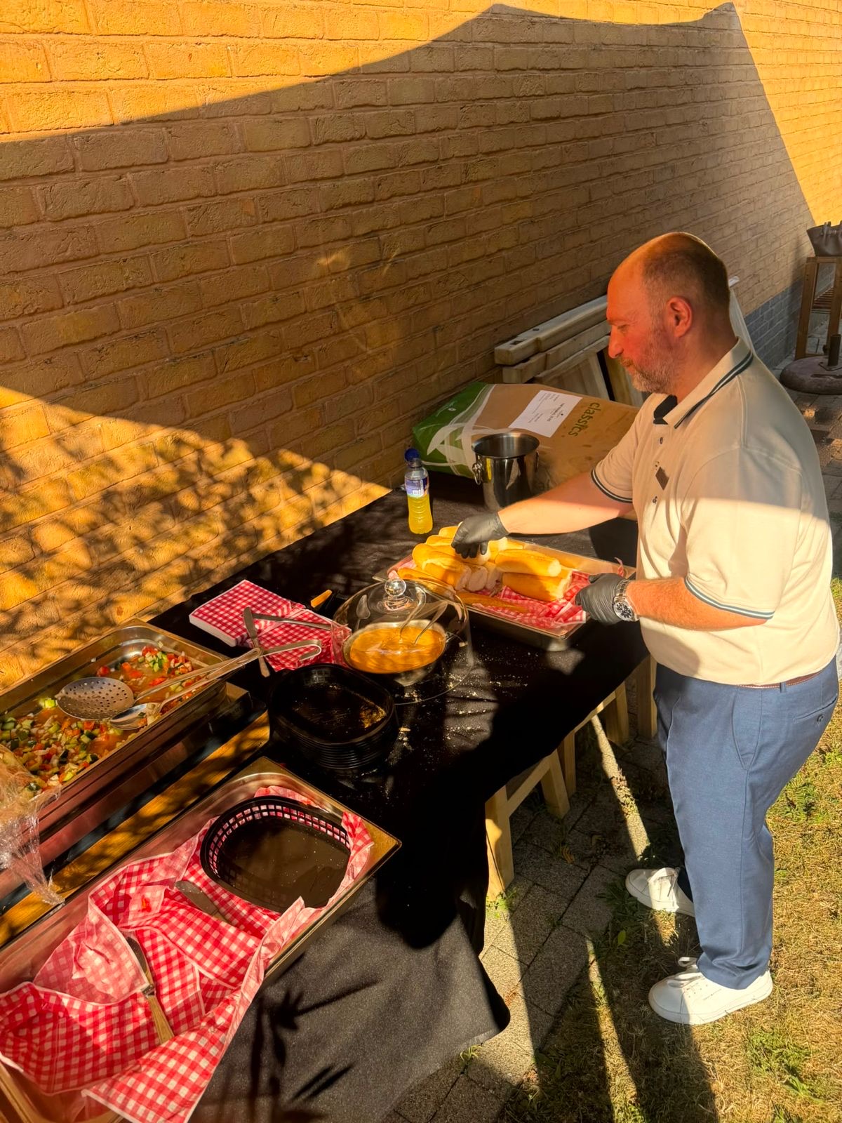 Broodjes klaarmaken tijdens de zomerbarbecue in de tuin