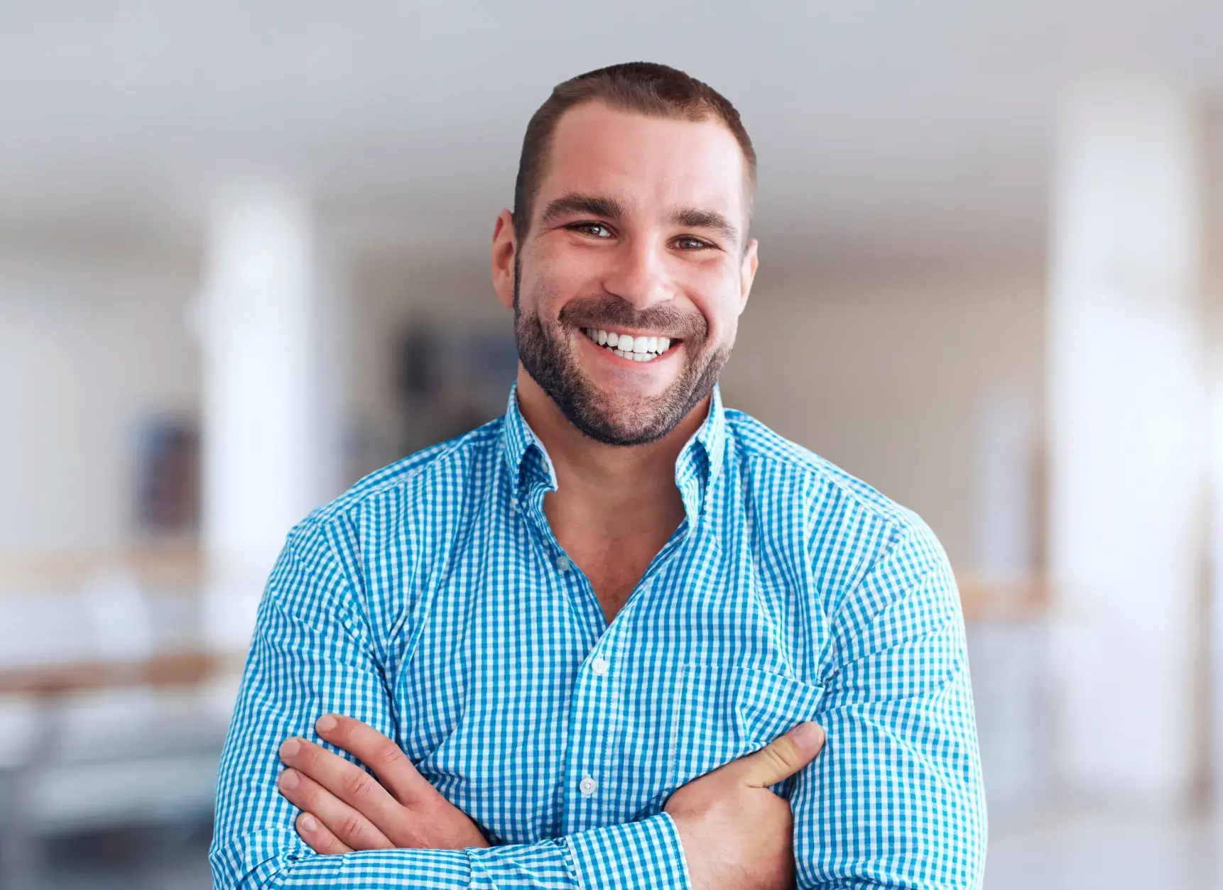 a man with his arms crossed smiling