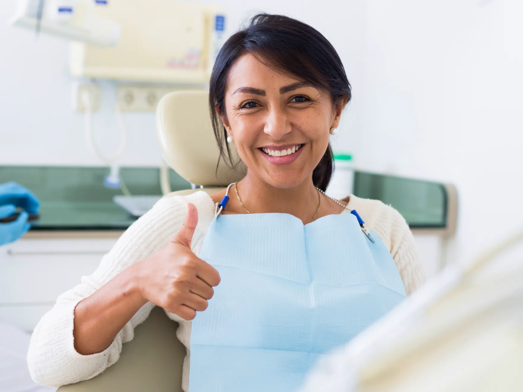 smiling woman sitting in a dental chair giving a thumbs up Dynamic Dental