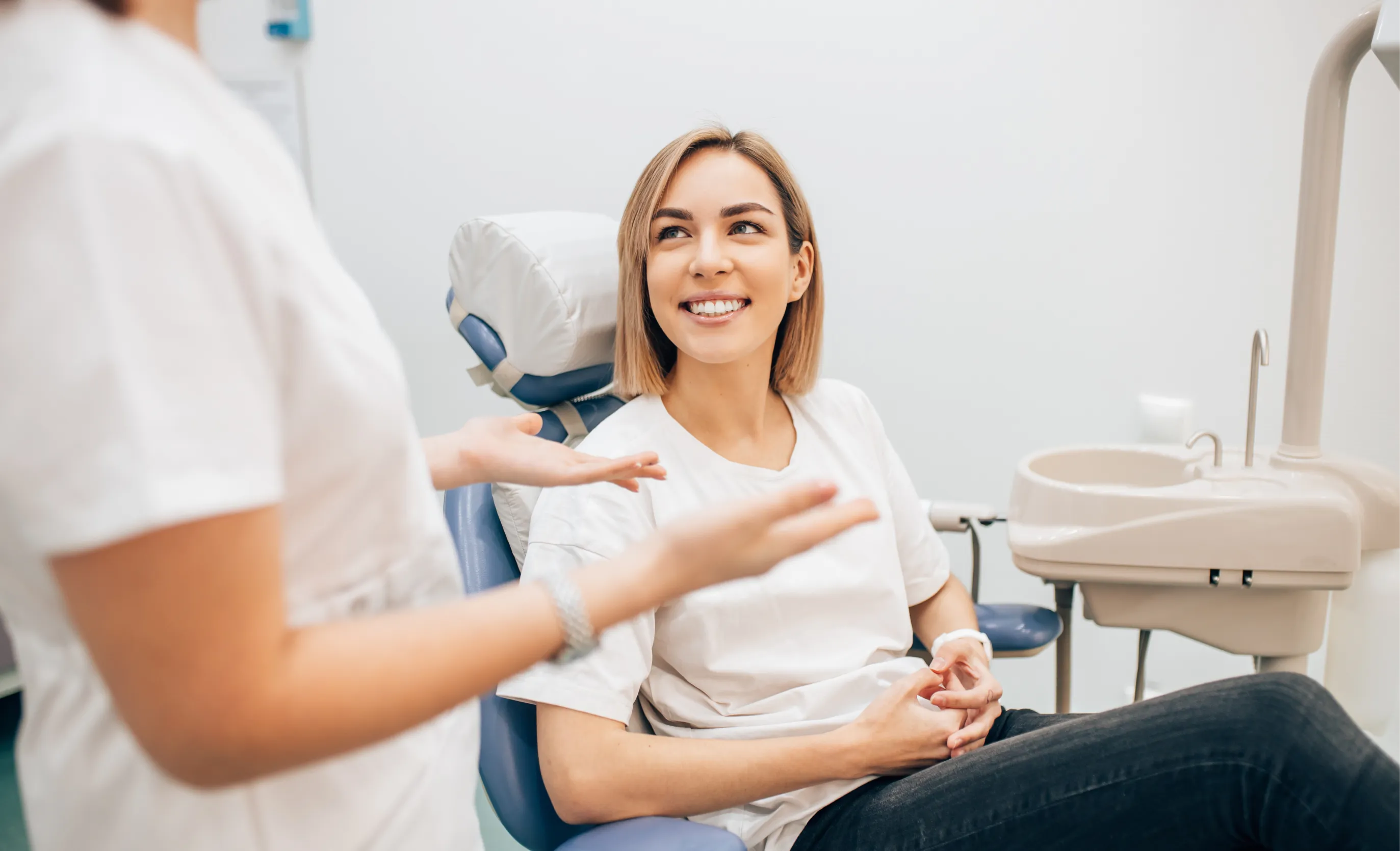 woman sitting in a chair in a dental office talking to a dentist Dynamic Dental