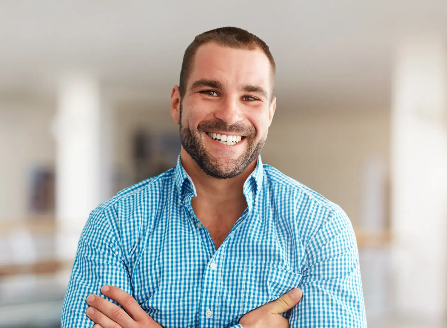 smiling man in blue shirt with arms crossed in a room Dynamic Dental