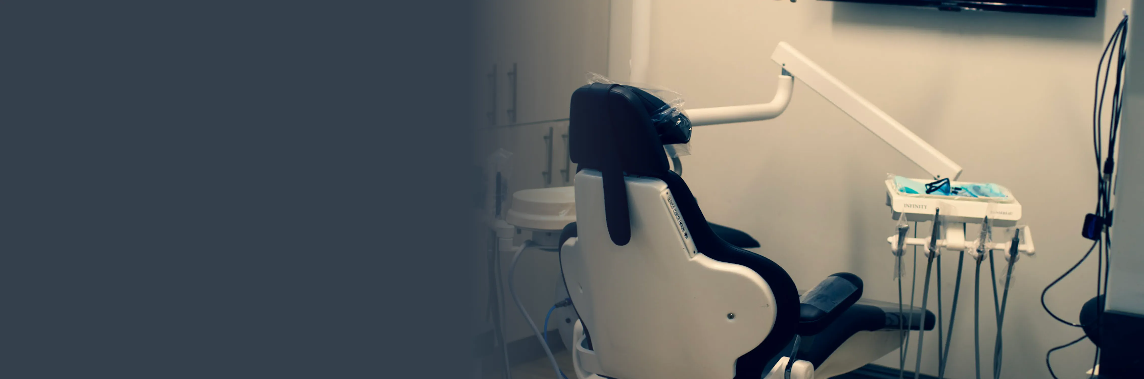 there is a chair in the room with a tv on the wall Dynamic Dental