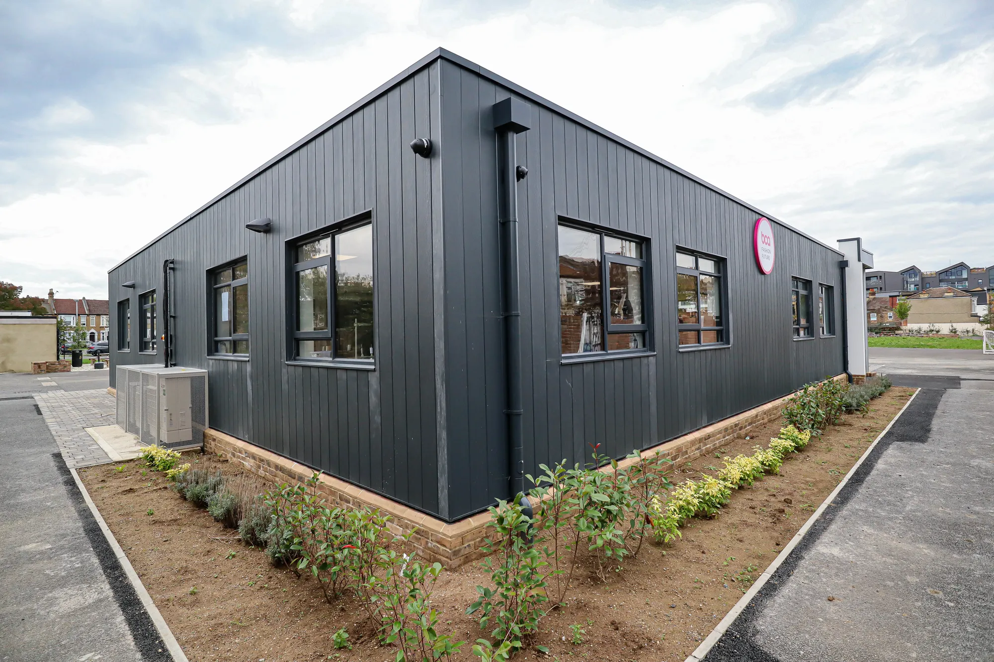 Big Creative Academy, London: dark clad exterior of the teaching block with new planting