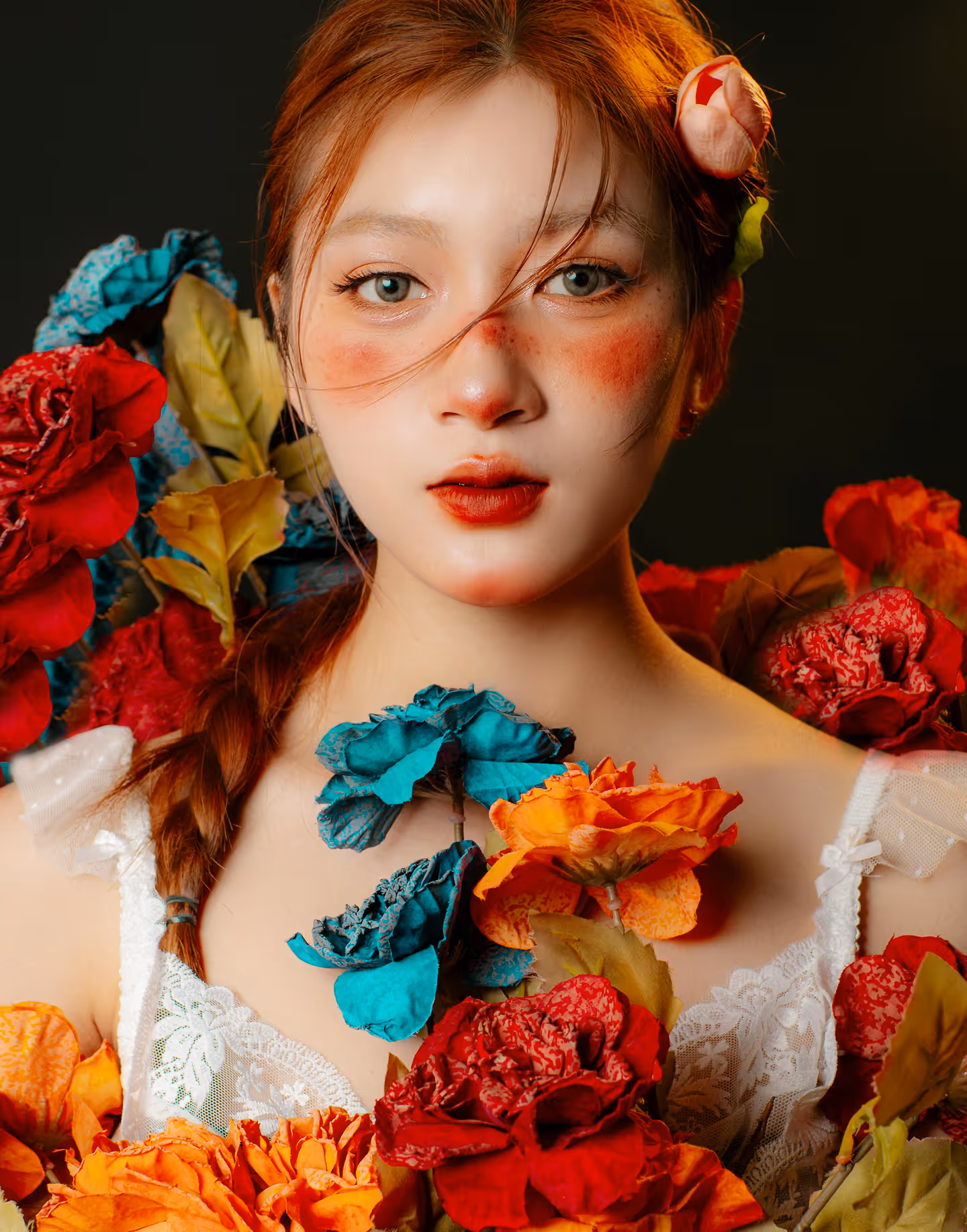 A beautiful studio portrait of a young woman, surrounded by flowers.