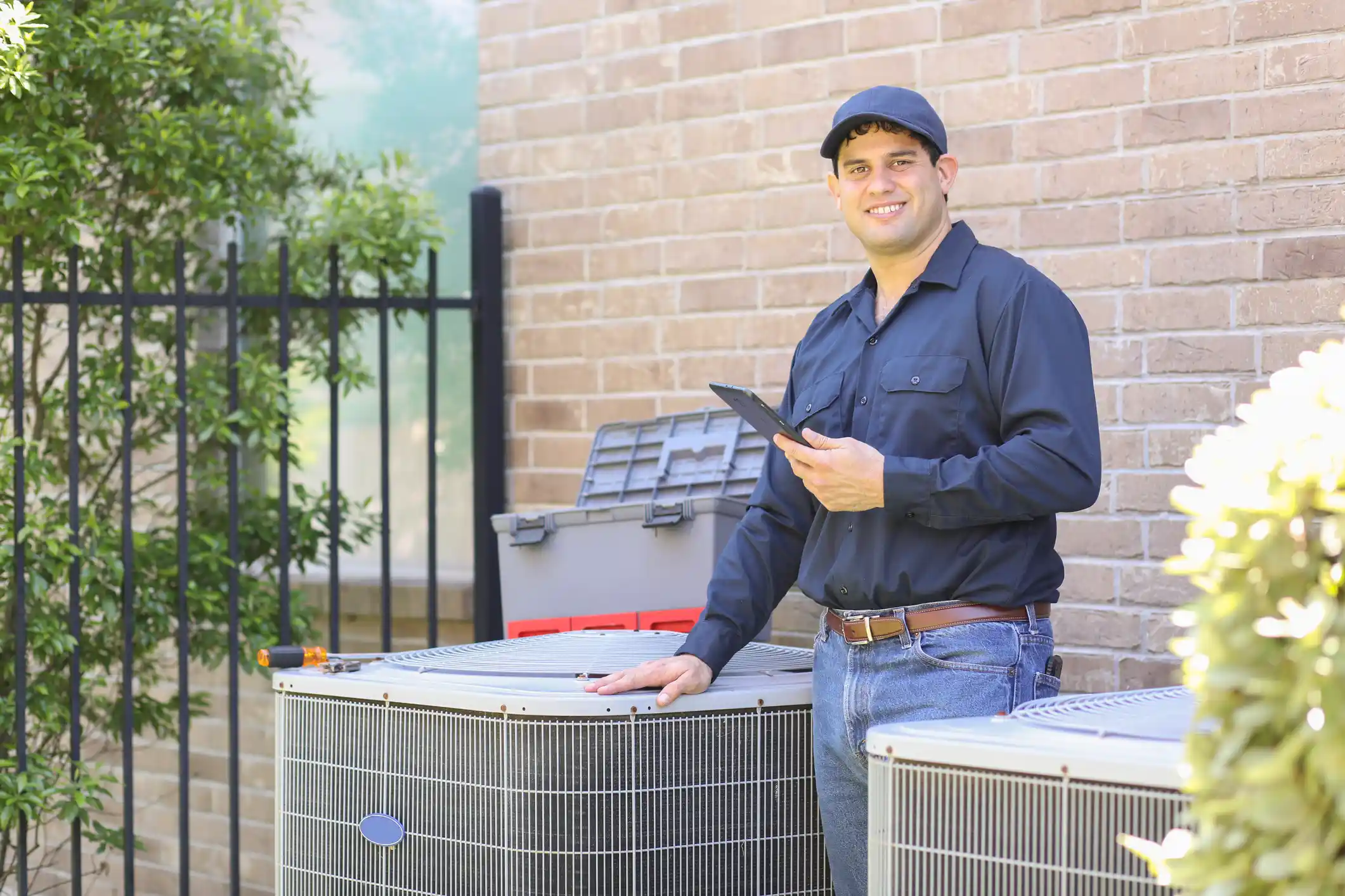 technician holding tablet beside AC.