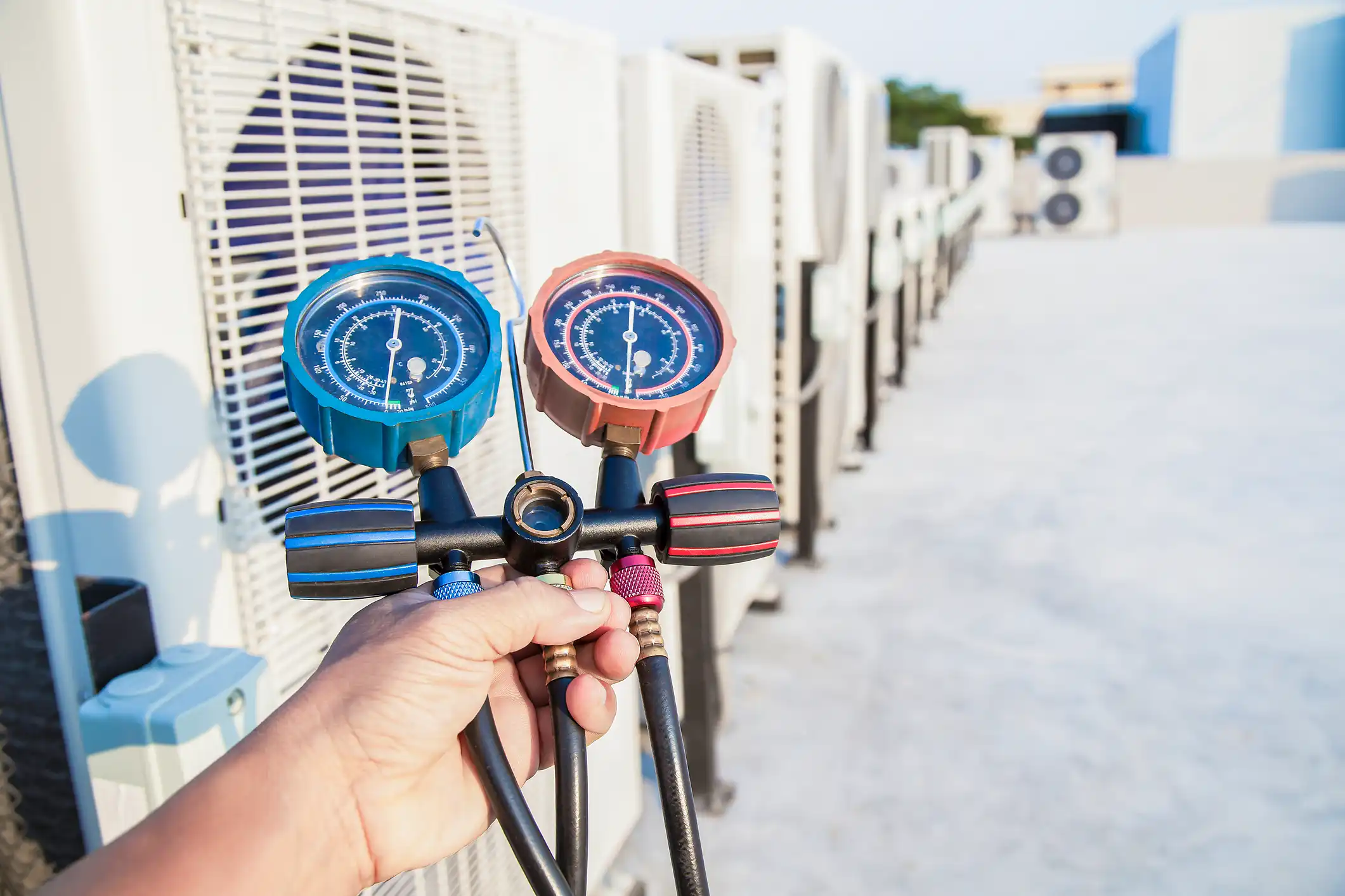 Technician holding manifold gauges for AC.