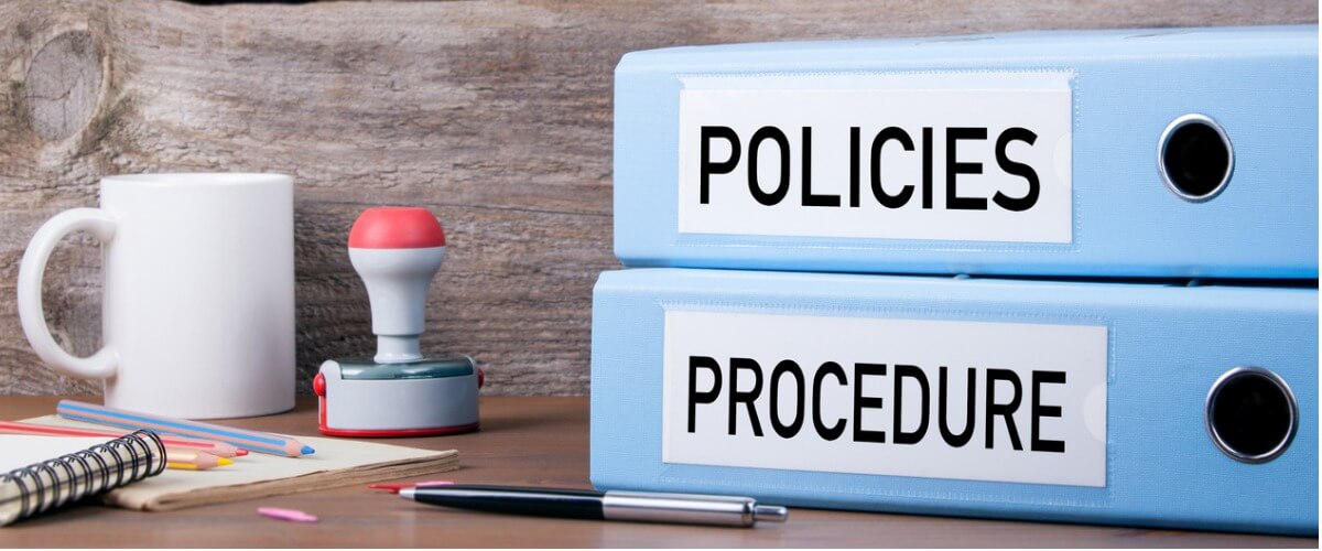 Two labeled folders titled "POLICIES" and "PROCEDURE" along with some office items – symbolizing administrative documentation and governance.