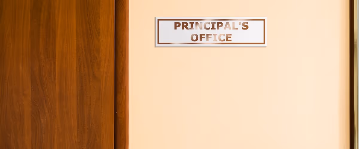 A door with a sign that reads "PRINCIPAL'S OFFICE" – indicating the entrance to the head office of a school.