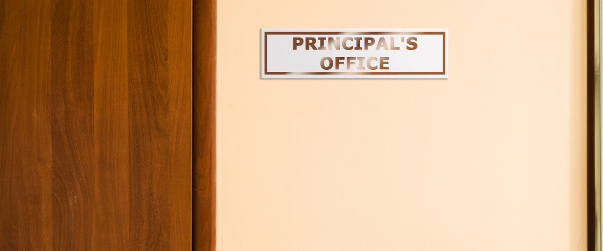A door with a sign that reads "PRINCIPAL'S OFFICE" – indicating the entrance to the head office of a school.