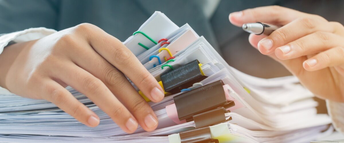Business woman working at desk with papers and calculator, planning budget in office.