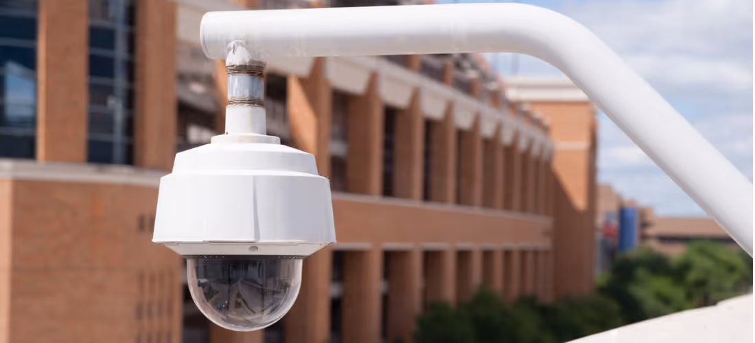 video-security-camera-housing-mounted-high-on-college-campus-picture-id473326392