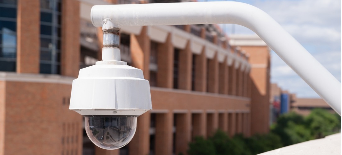 video-security-camera-housing-mounted-high-on-college-campus-picture-id473326392