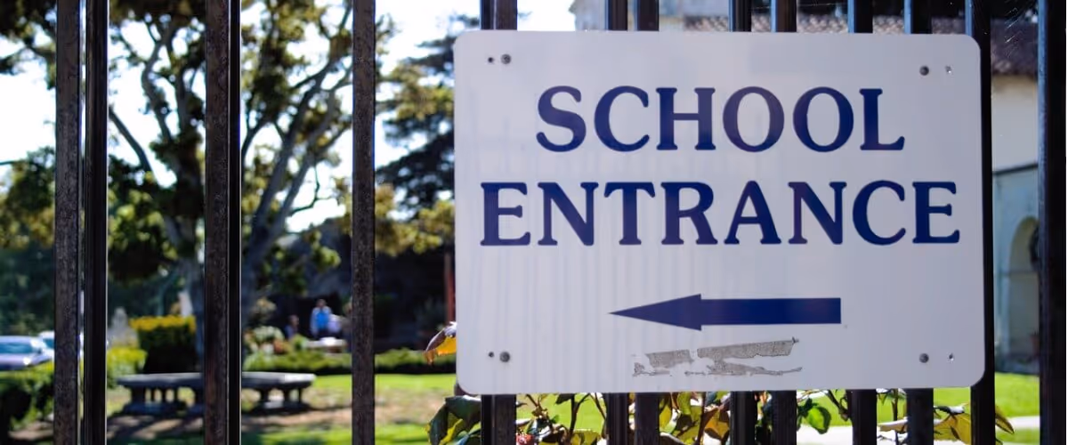 Secured school entrance sign on gated fence — a key part of school safety measures and visitor management protocols