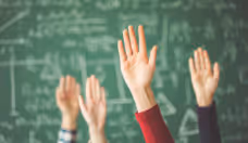 Students raised up hands green chalk board in classroom