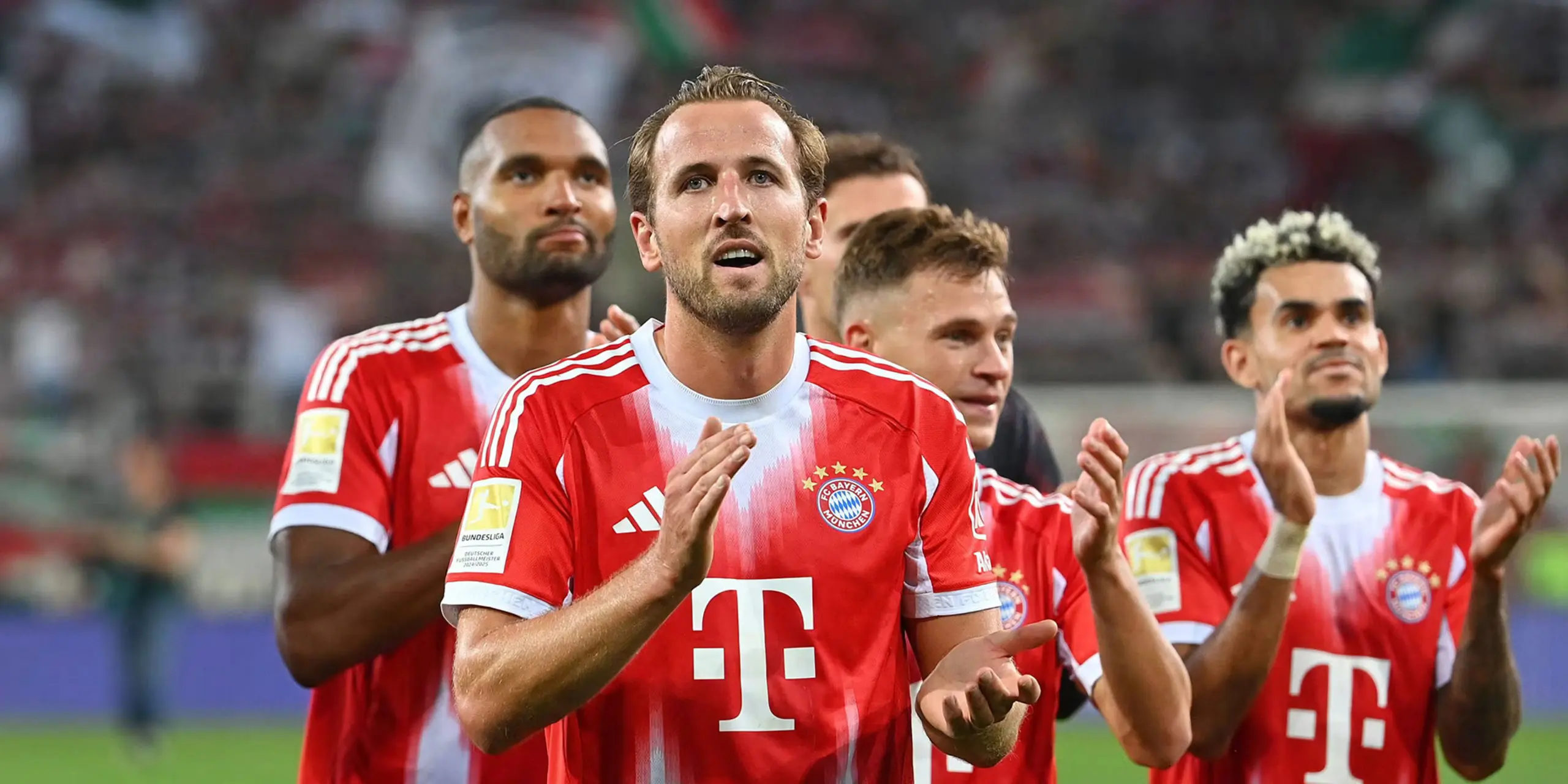Bayern Munich players wearing red and white jerseys applaud on the pitch after a match.