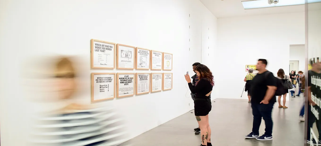People standing in front of typographic artwork in a museum or gallery