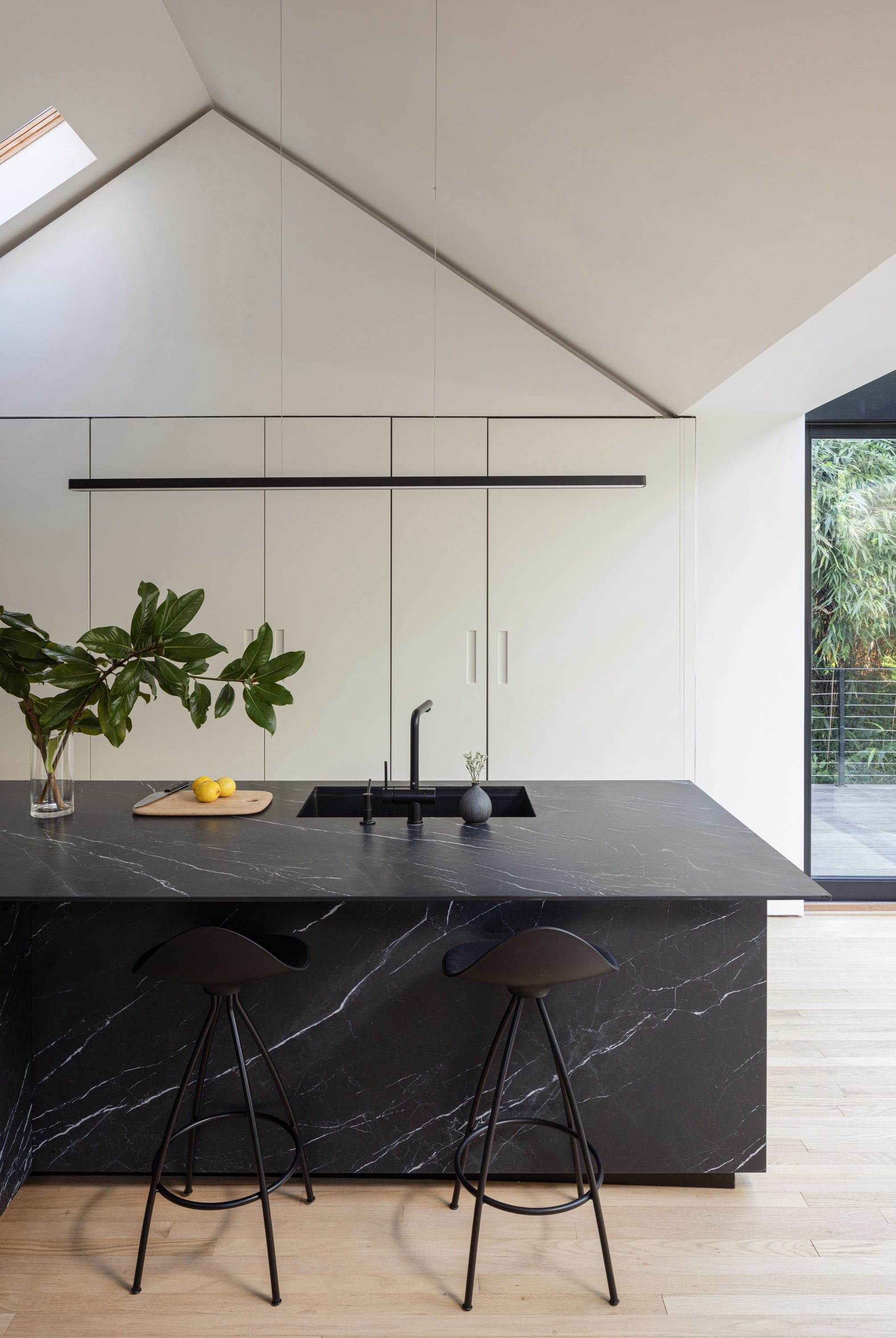 Kitchen with marble island, bar stools, and built-in ovens.