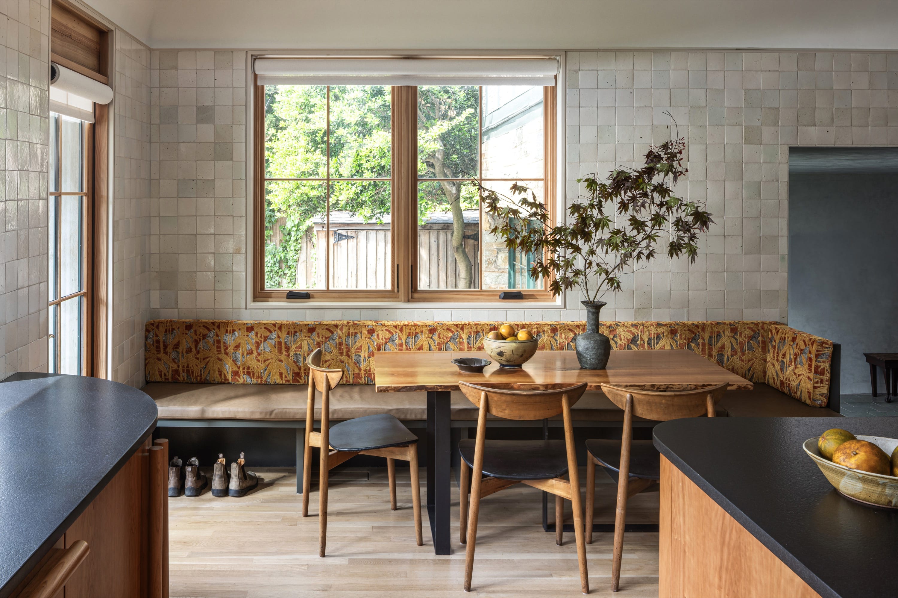 Dining area with built-in bench and large window.