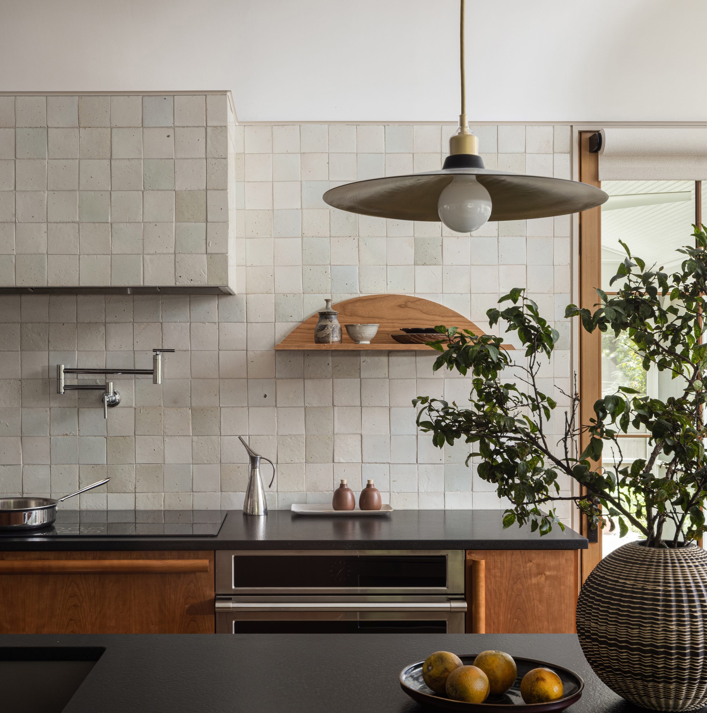 Kitchen with marble backsplash and modern lighting.