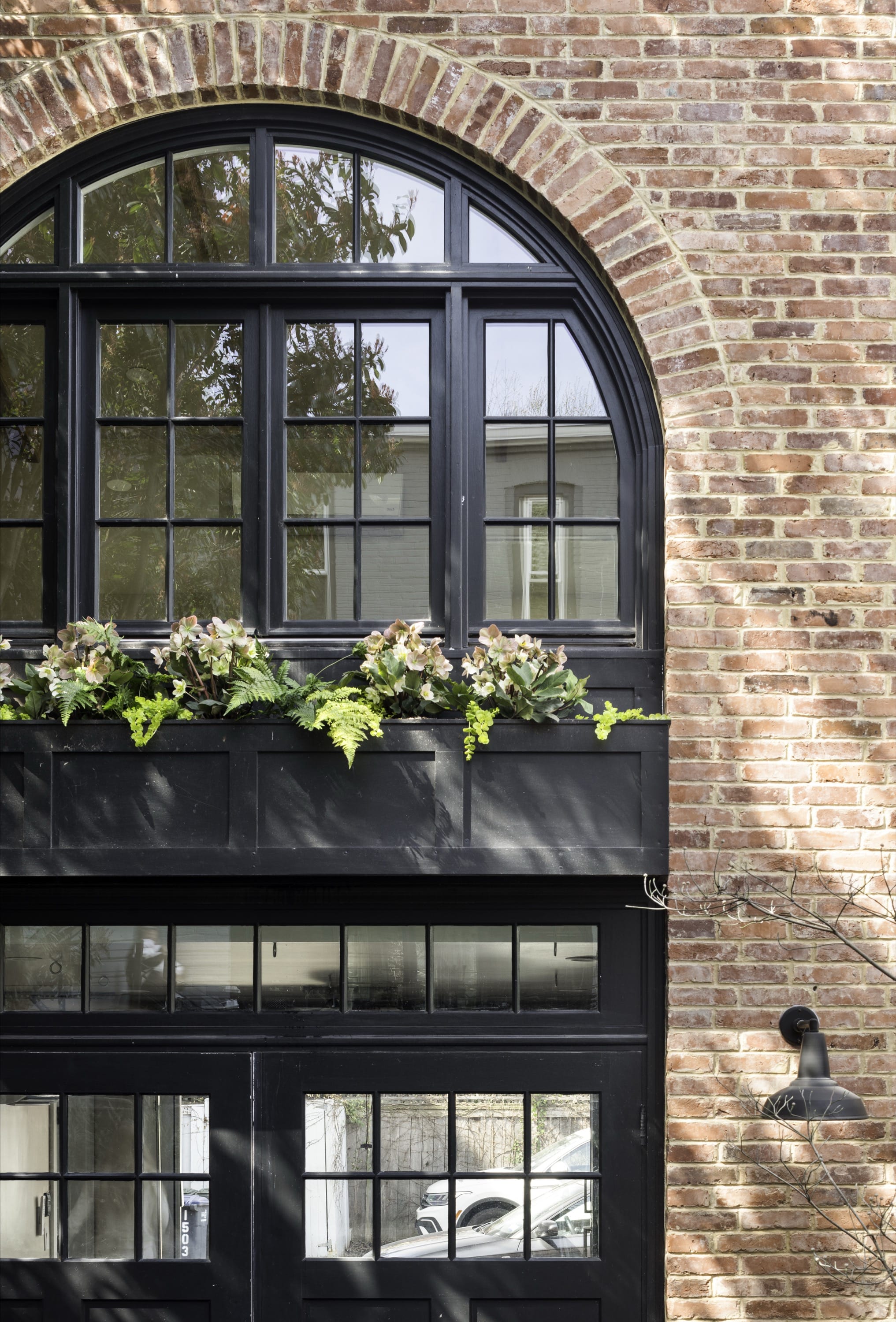 Two-story brick facade with garage and upper windows.