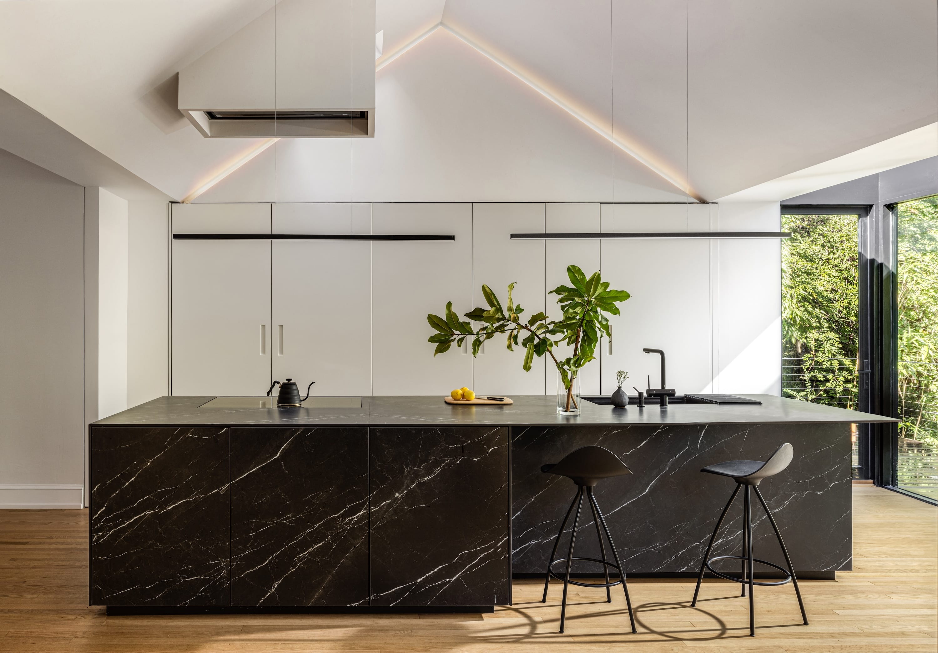 Bright kitchen with black island and vaulted ceiling.