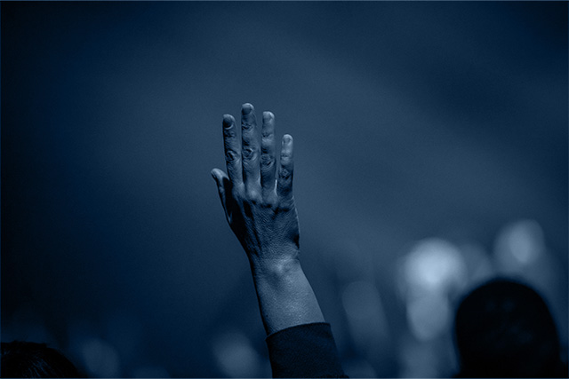 A person raising their hand, symbolizing the idea of owning your impact.