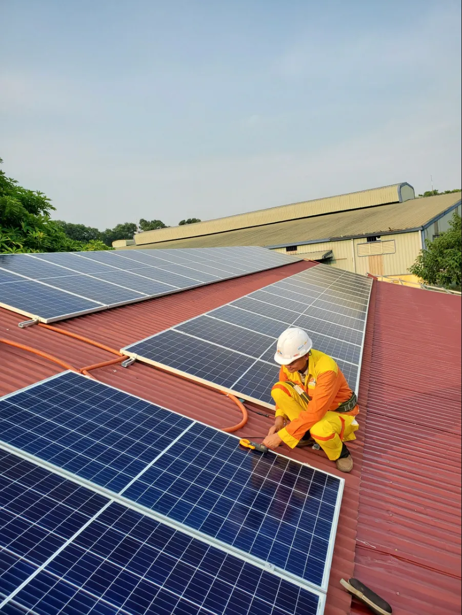 Image of a technician working on a roof solar panel
