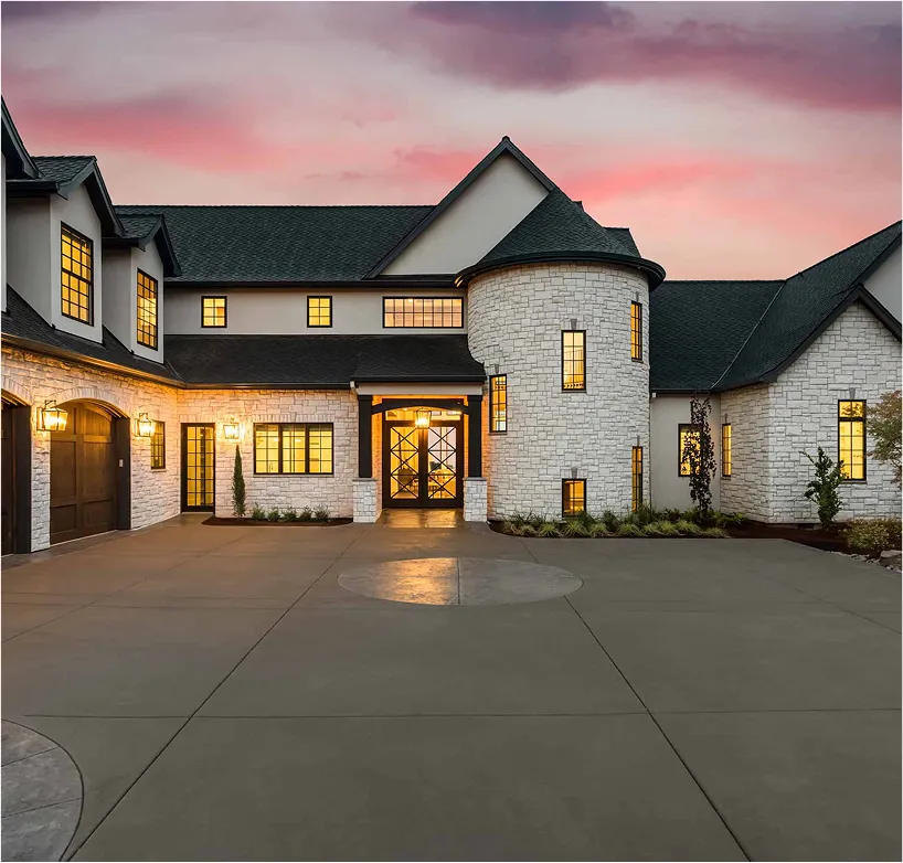 Modern white-brick villa with yellow lights captured at sunset