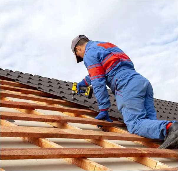 A man installing metal sheeting on the roof.