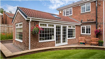 Brick house with a new home extension featuring large windows and a patio.
