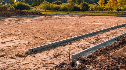 Prepared construction site with forms set for pouring a concrete slab foundation.