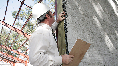 Construction worker applying stucco or plaster to an exterior wall surface.