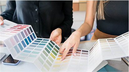 Two people selecting paint colors from a palette of color swatches.