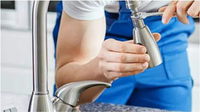 A person installing or adjusting a faucet in a kitchen or bathroom sink.