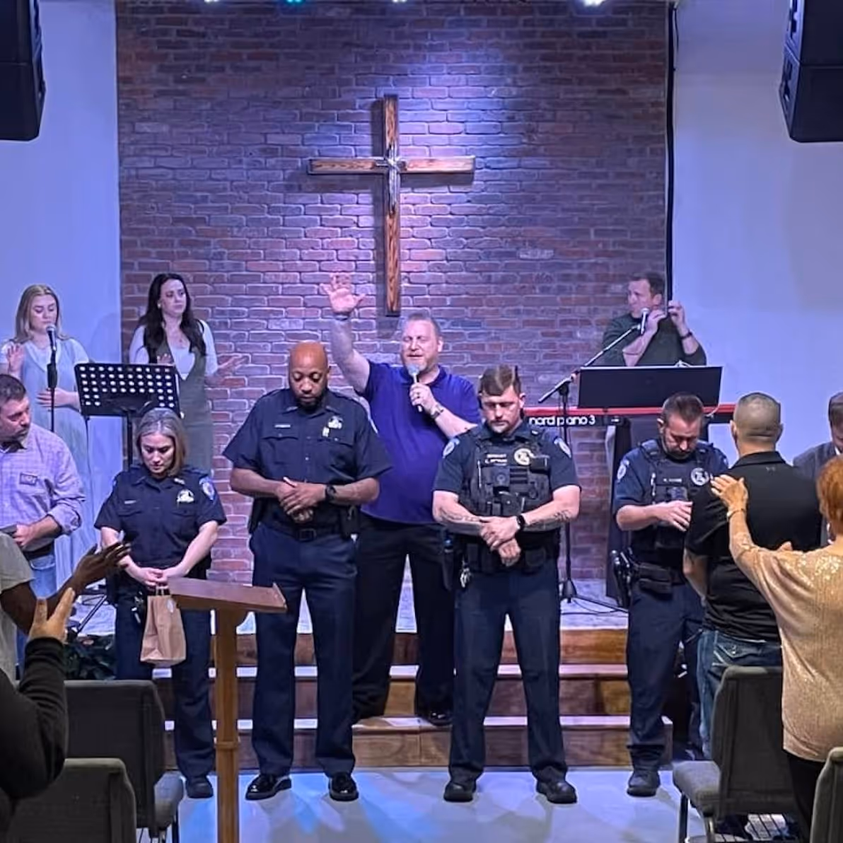 A member of the Northshore Gospel Network (Chad Richardson) praying of police officers and the mayor serving in their city at Celebration Church Mandeville/Covington