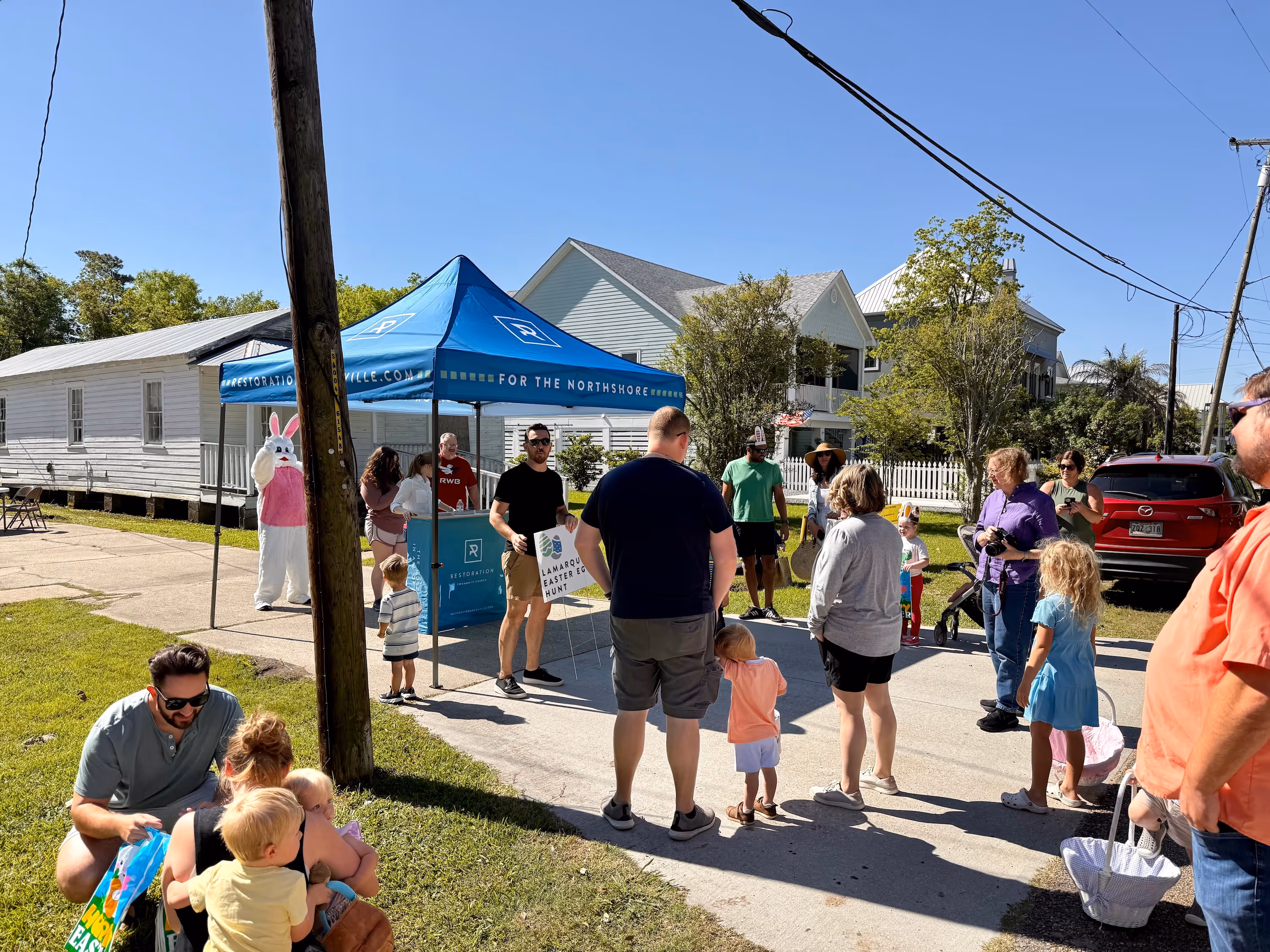 A member church of the Northshore Gospel Network (Restoration Community Church) gathering families in front of their tent for a streetwide Easter Egg Hunt