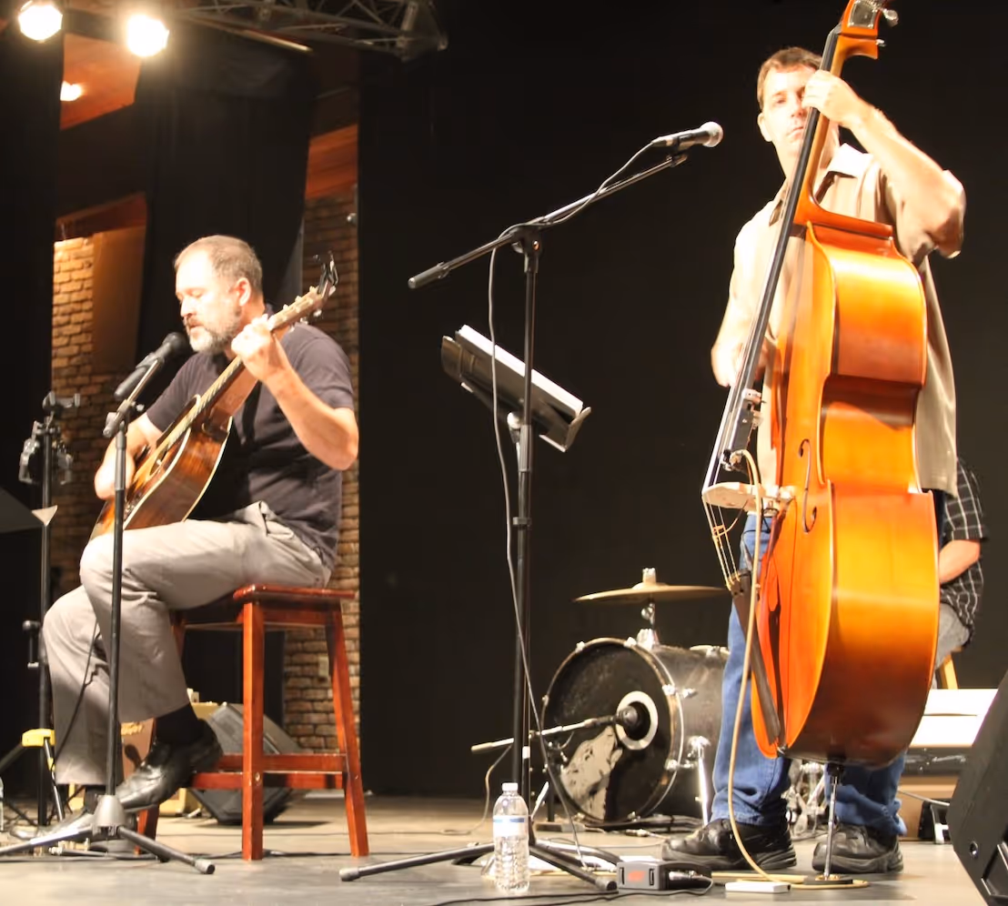 A band playing standing base and guitar at a worship event on the Northshore