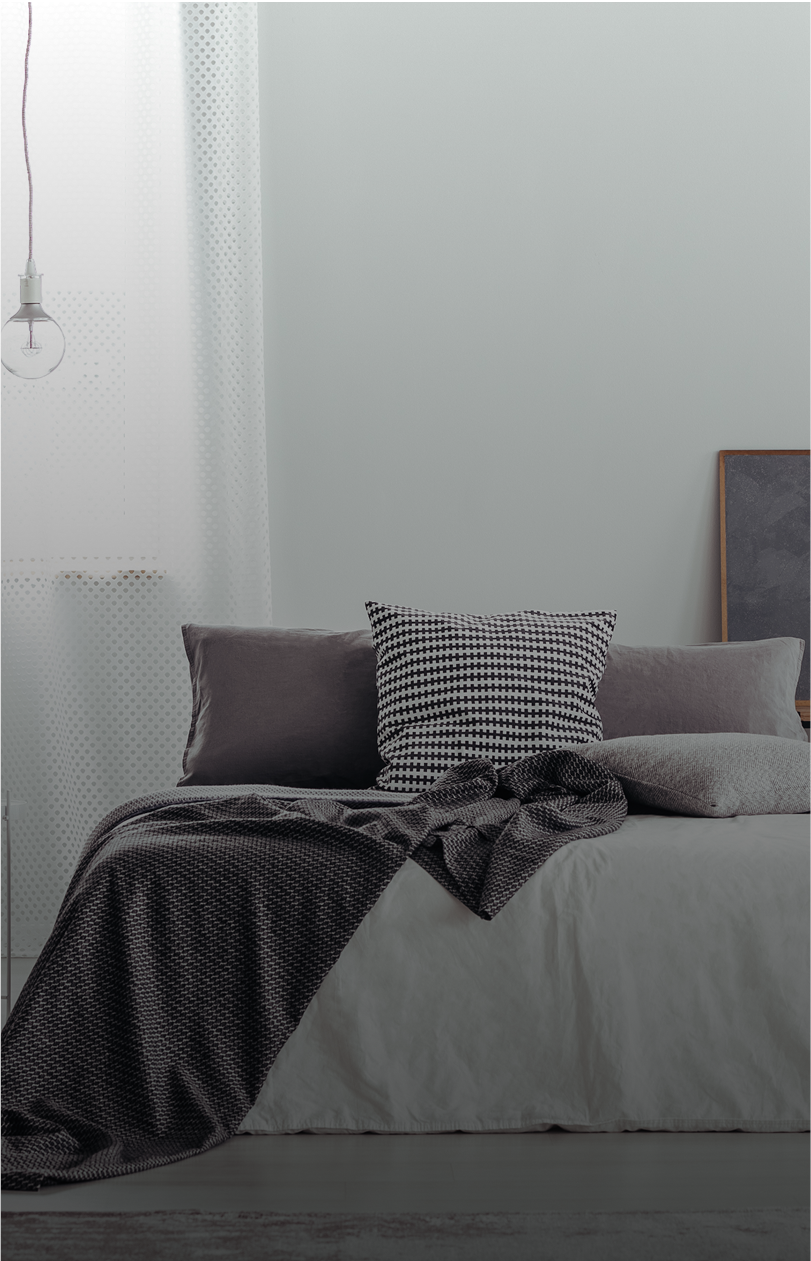 Monochrome bedroom interior design with houndstooth accent cushion and layered bedding, showcasing soft textures and calming decor