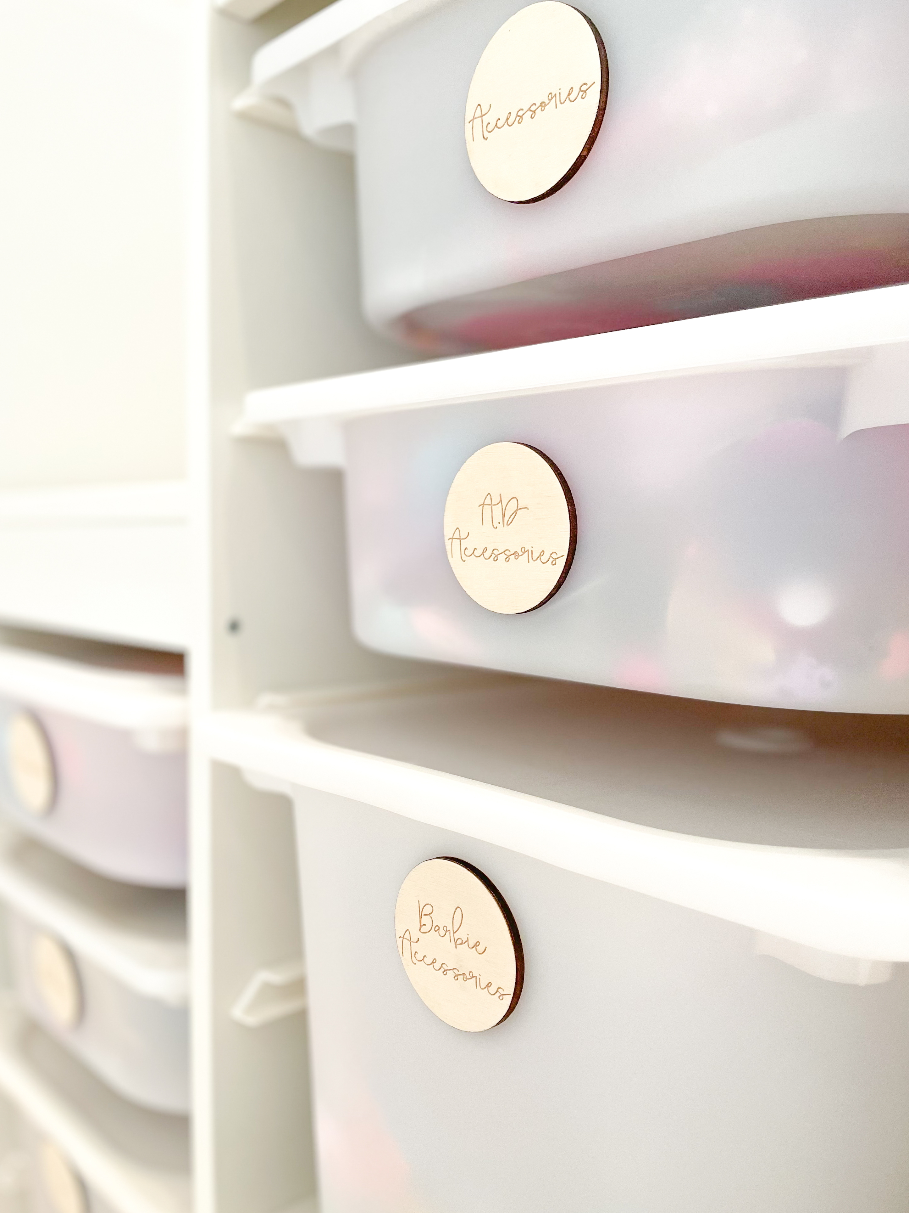 Close-up of minimal toy storage drawers with custom wooden labels, showcasing neat organisation in a stylish and functional kids’ playroom.