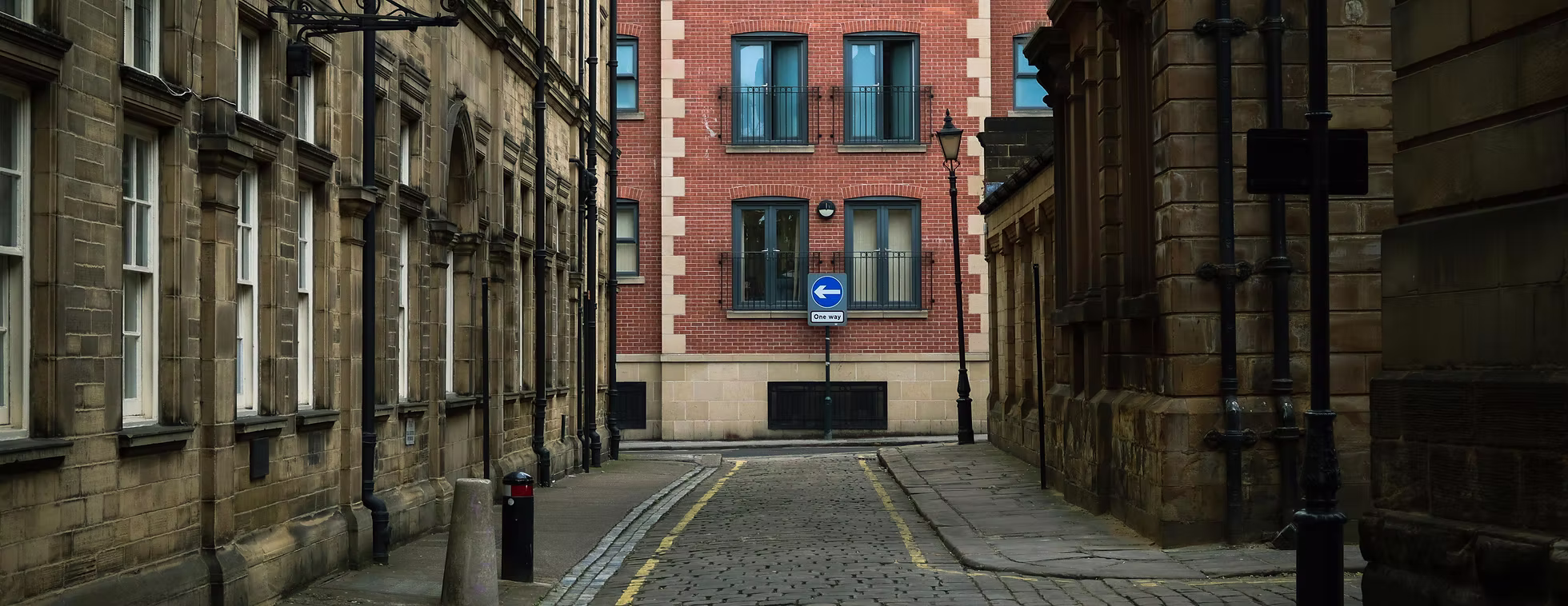Interior design in Wakefield featuring a quiet urban street blending traditional Yorkshire stone architecture with contemporary red-brick apartments