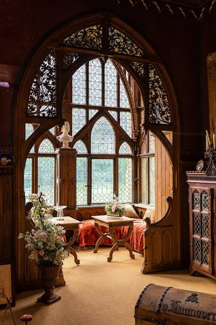 Vintage-inspired interior with ornate arched windows, carved wood details, and autumnal seating area — Roberts Renovations highlighting heritage design trends 2025