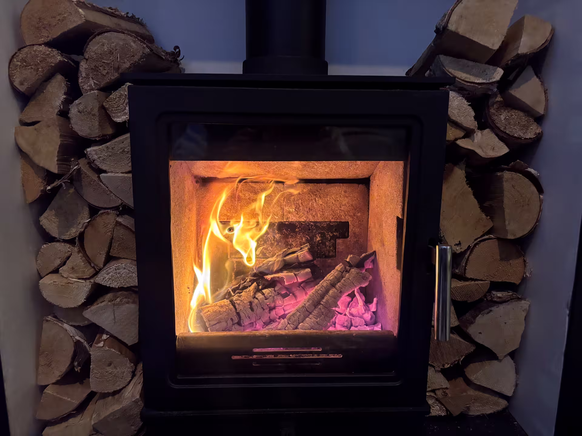 Log burner providing warmth and comfort in a cosy living room during winter home preparation.