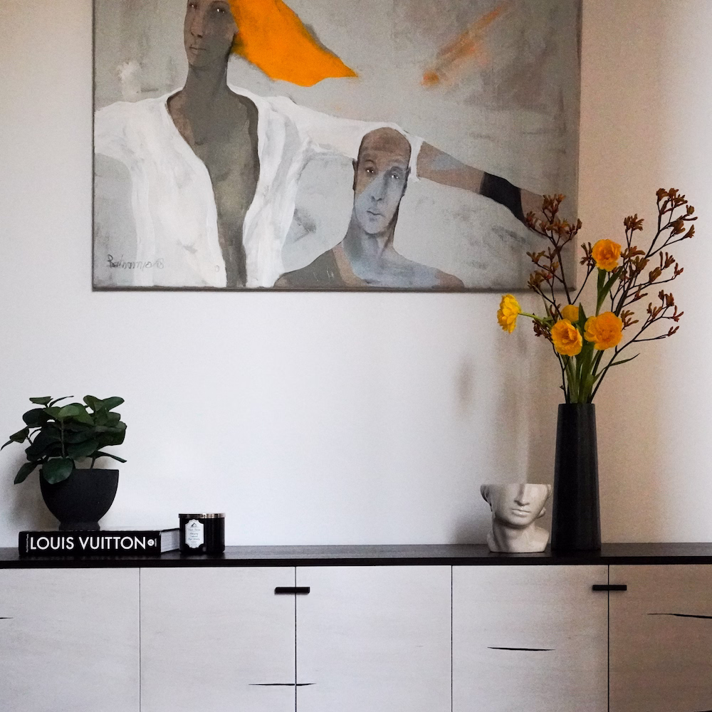 Close-up of artwork and accessories adding colour and personality to modern living room design.