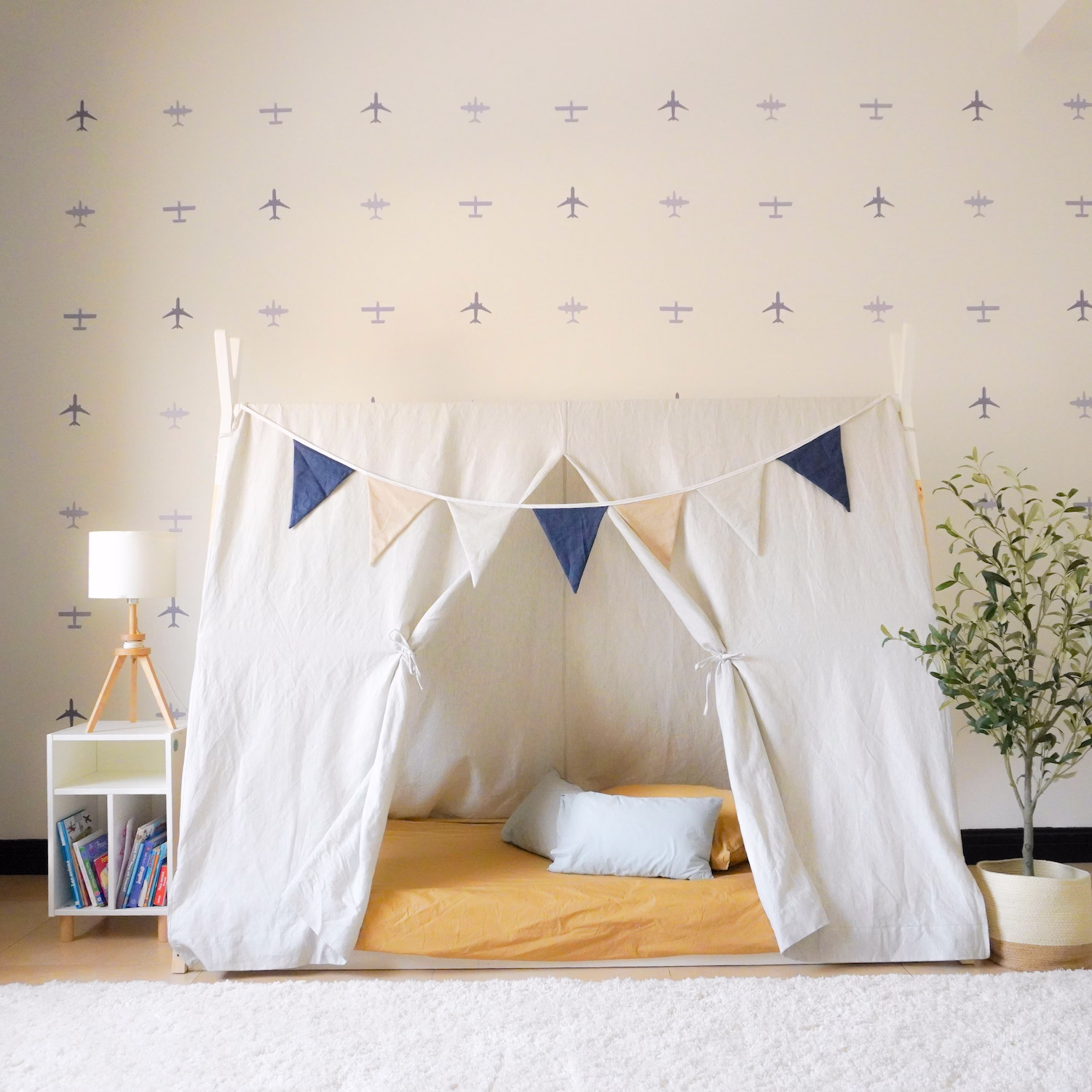 Aeroplane-themed boys’ bedroom with tipi bed, custom wall sticker, and soft blue tones by Roberts Renovations.