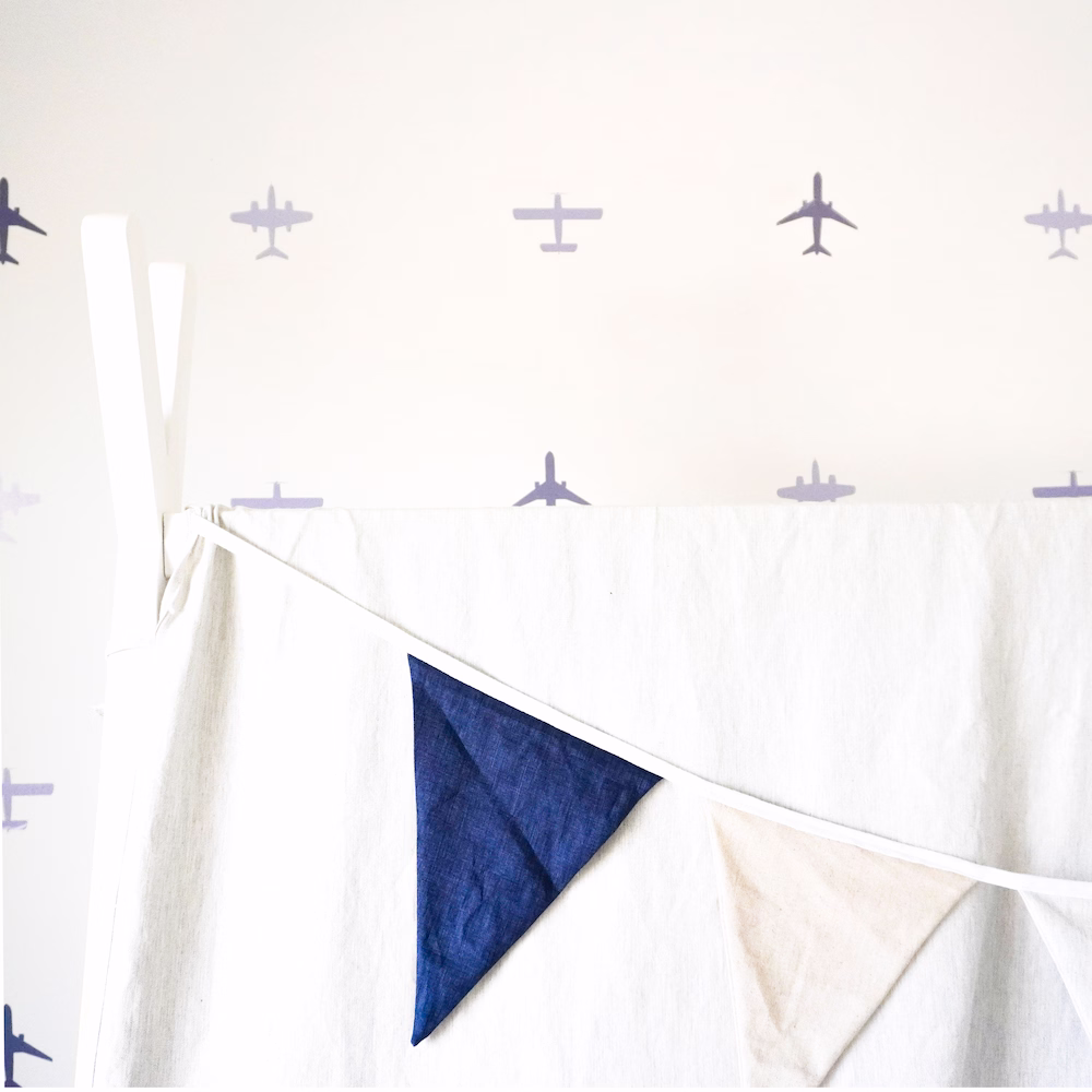 Custom aeroplane sticker wall with blue geometric decals in boys’ aviation-themed bedroom by Roberts Renovations.