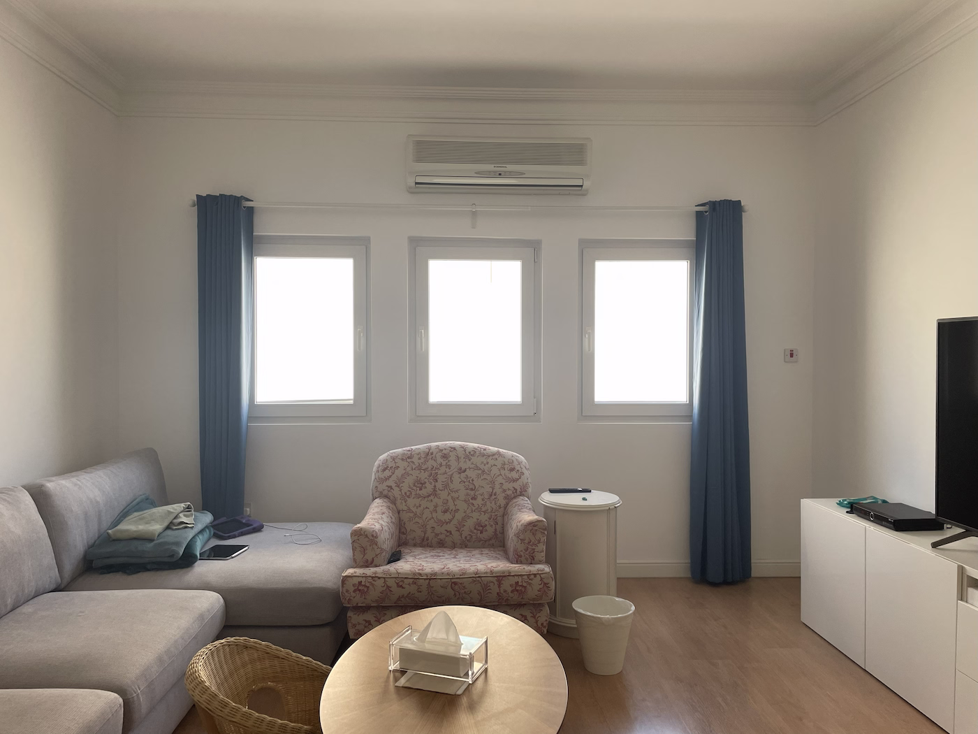 Before image of dated living room with minimal décor and neutral furniture prior to Roberts Renovations redesign.