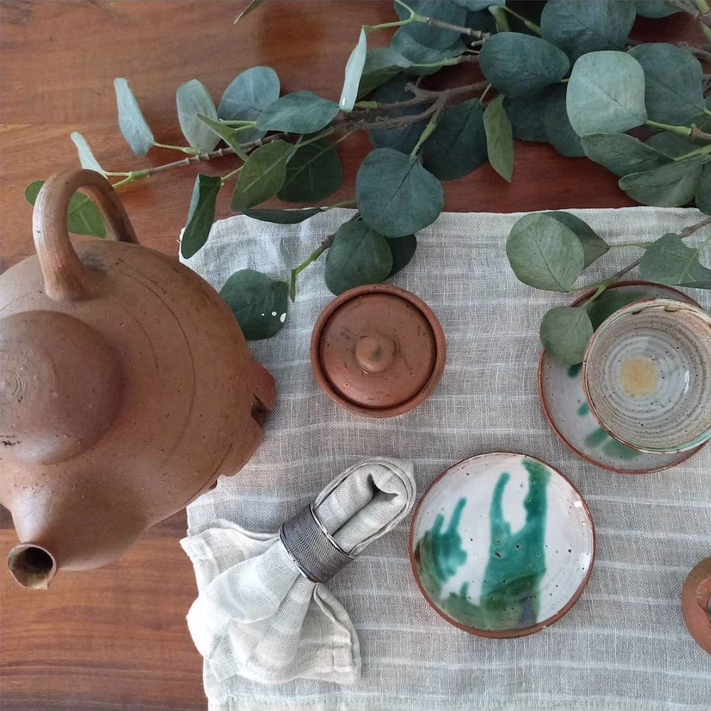 Dining table decor styled by Roberts Renovations, featuring handcrafted ceramics, natural linens, and greenery that create a warm, organic, and inviting dining atmosphere.