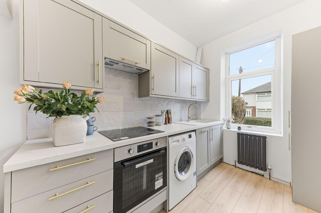 Modern taupe kitchen renovation in Pudsey buy-to-let property with gold handles and integrated appliances